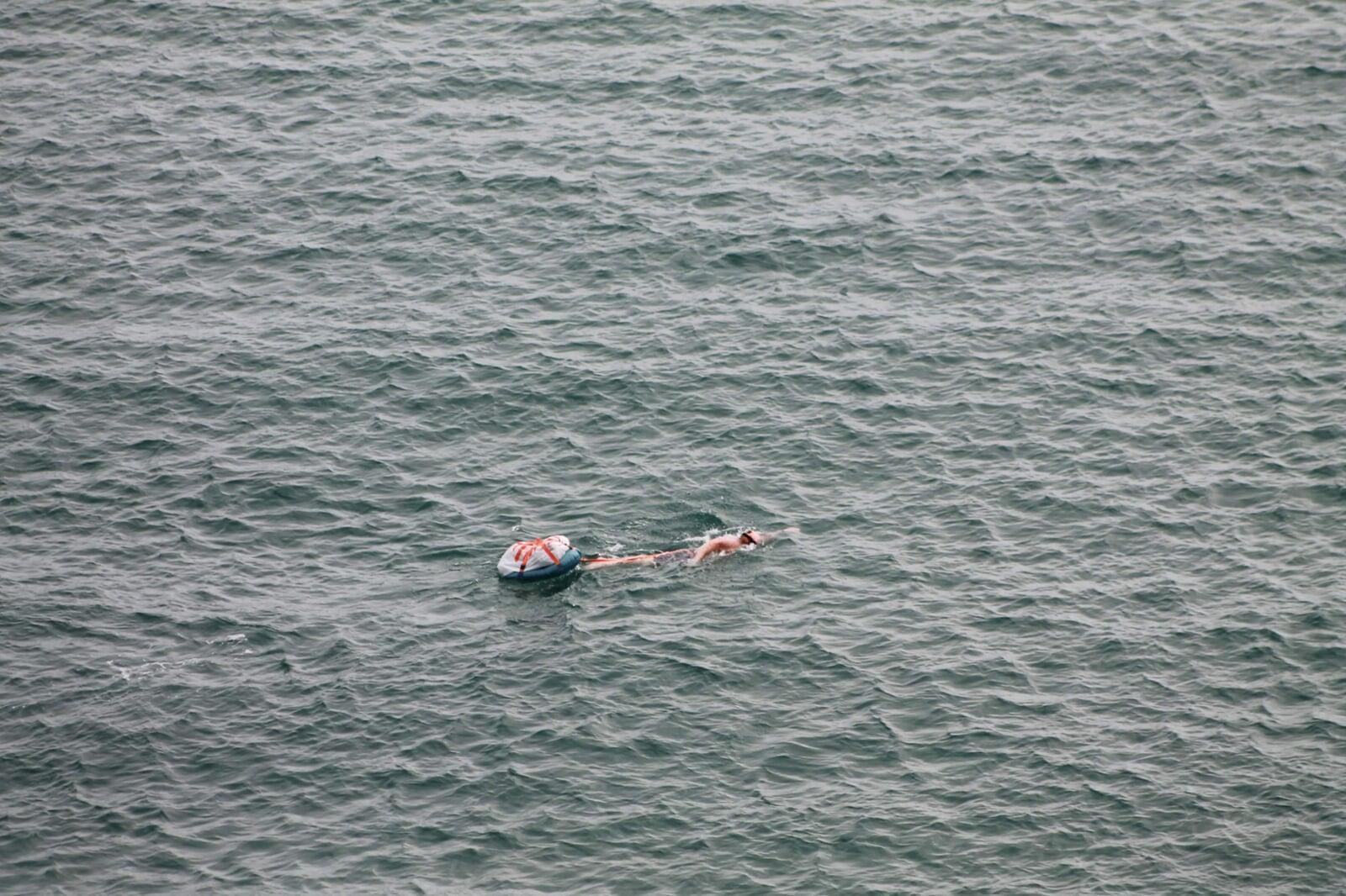 SwimHiking with rucksack and camping gear in open water Pembrokeshire